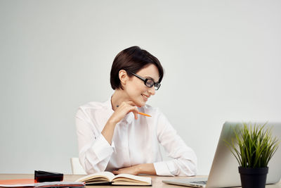 Businesswoman sitting against white background