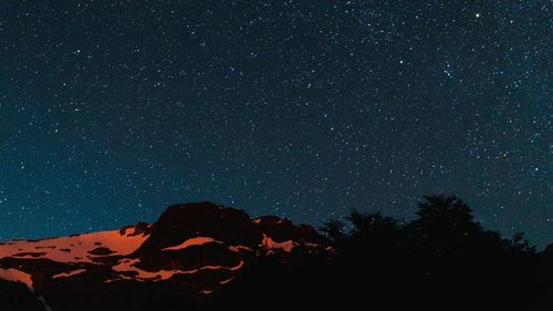 Low angle view of silhouette mountain against sky at night