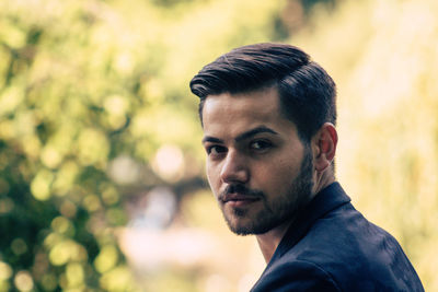 Close-up portrait of businessman against trees