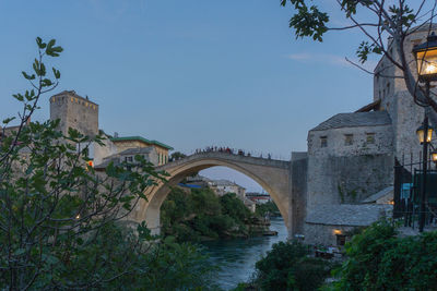 Arch bridge over river against sky