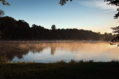 Scenic view of lake against sky at sunset