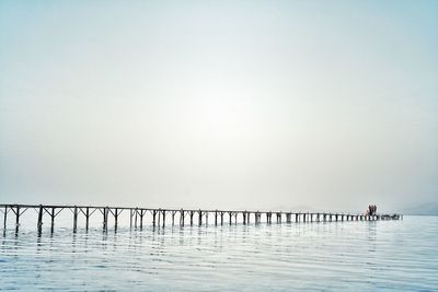 Pier on sea against clear sky