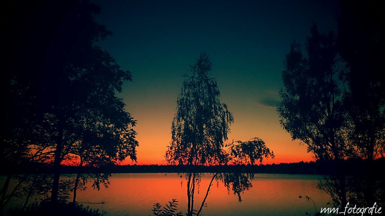 water, tree, sunset, reflection, lake, silhouette, tranquil scene, tranquility, scenics, beauty in nature, waterfront, nature, idyllic, sky, orange color, majestic, calm, river, outdoors, growth