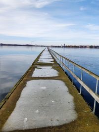 Pier over river against sky