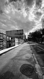 Road by buildings in city against sky