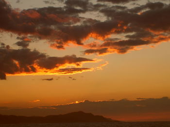 Scenic view of silhouette mountain against orange sky