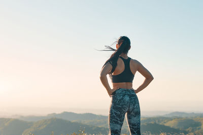 Rear view of woman standing against clear sky