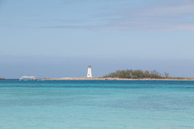 Lighthouse by sea against sky