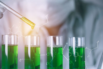 Digital composite image of man examining chemical in laboratory