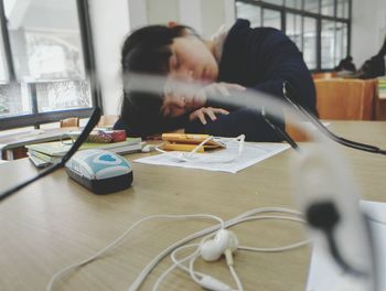 Young woman sleeping on library desk