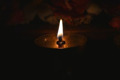 Close-up of lit candle in the dark