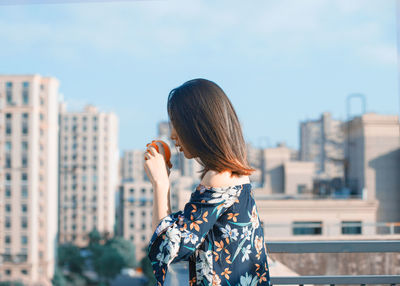 Woman standing against buildings in city