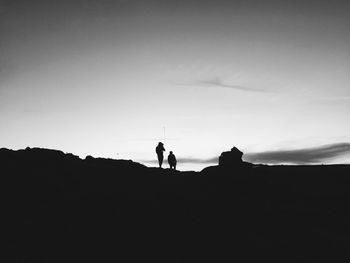 Silhouette of friends against sky