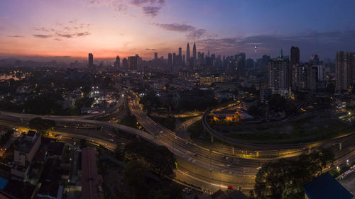 High angle view of city buildings against sky during sunset