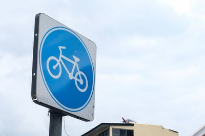 Low angle view of road sign against sky