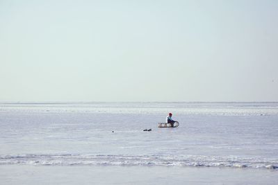 Man in sea against clear sky