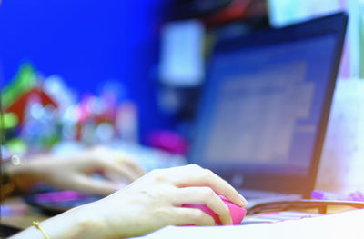 Close-up of hand using laptop on table