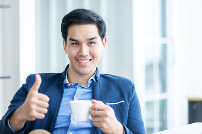 Portrait of smiling man holding coffee cup