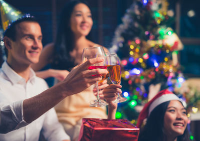 Friends toasting drinks at christmas party