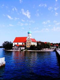 View of temple by river against sky