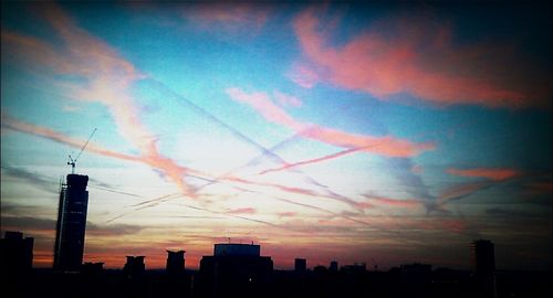 Silhouette of buildings against cloudy sky