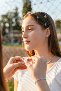 Teenage girls putting flowers in hair