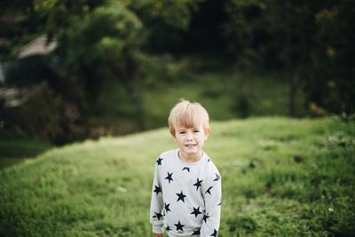 Portrait of cute boy standing on field