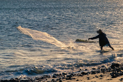 Fisherman standing at beach