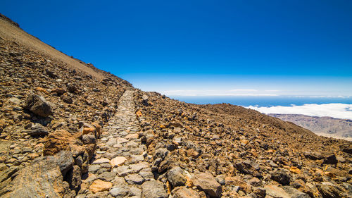 Walkway on mountain against blue sky