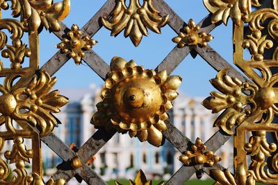 Low angle view of metal gate against sky