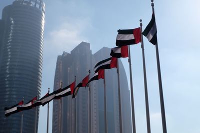 Low angle view of flags against sky