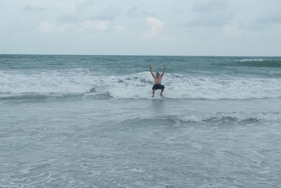 Man in sea against sky