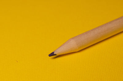 High angle view of colored pencils on yellow wall