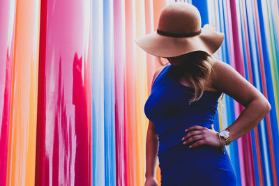 Woman standing against multi colored wall