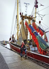 People in boat at harbor against sky