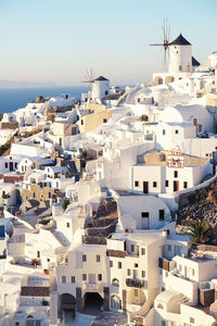 Whitewashed houses in town against clear sky