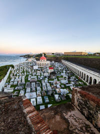 High angle view of buildings by sea against clear sky