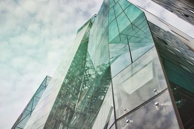 Low angle view of glass building against sky