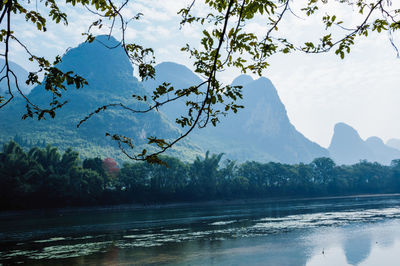 Scenic view of lake by mountains against sky