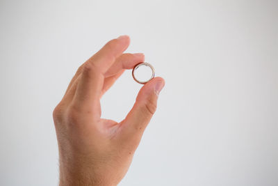 Close-up of hand holding hands over white background