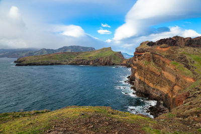 Scenic view of sea and mountains against sky