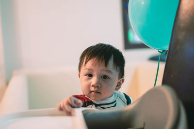 Portrait of cute baby boy sitting at home