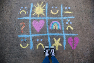 Low section of man standing by drawing on street