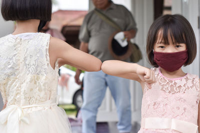 Social distancing. two children bump elbows new novel greeting.