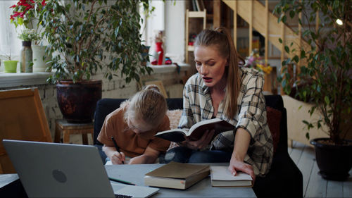 Mother teaching daughter at home