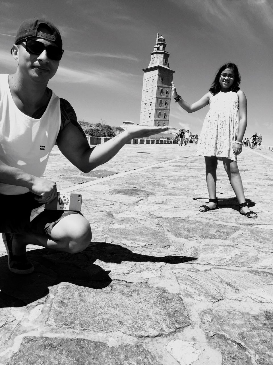 sunglasses, beach, real people, full length, vacations, leisure activity, young adult, casual clothing, day, outdoors, sand, young women, sunlight, sea, happiness, architecture, built structure, building exterior, water, smiling, sky, nature, one person, people