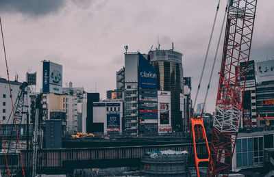 View of crane in city against sky