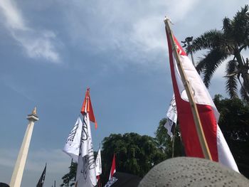 Low angle view of flags against sky