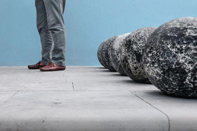 Low section of man standing against rocks on footpath