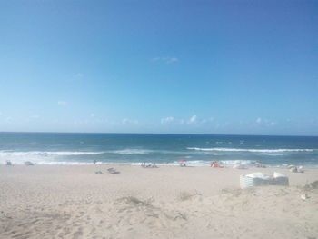 Scenic view of beach against blue sky